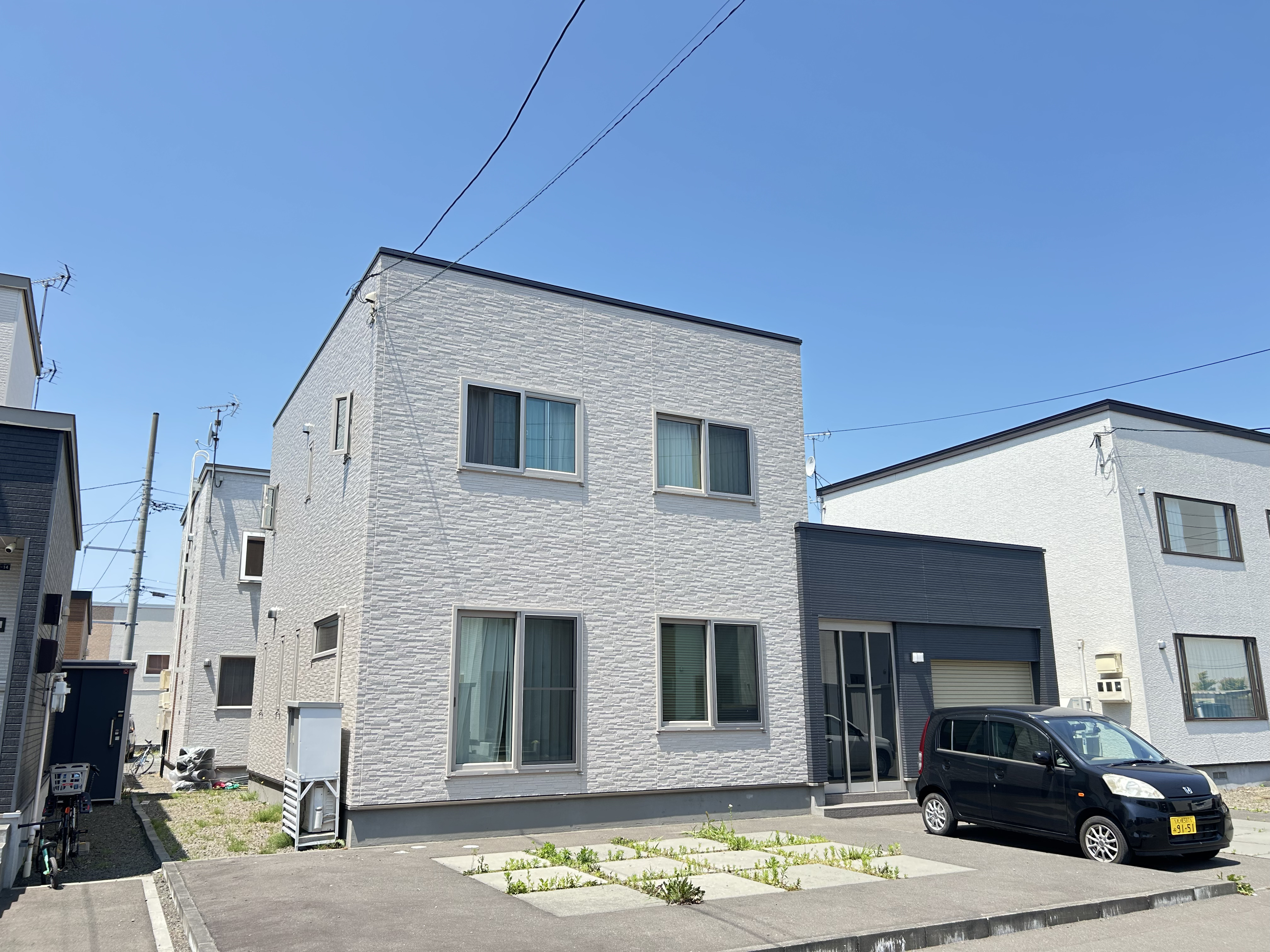 直線的なシルエット×石調素材の陰影で洗練された宅邸