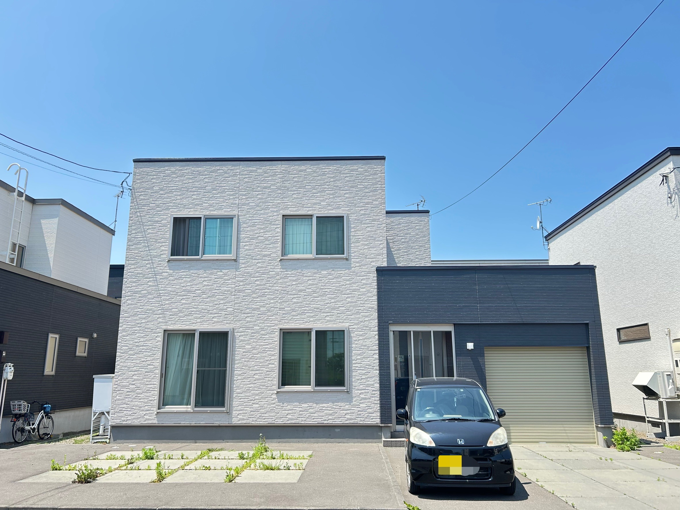 直線的なシルエット×石調素材の陰影で洗練された宅邸